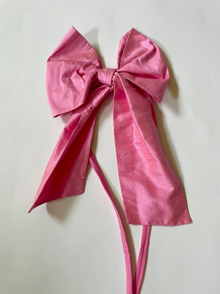 Large pink silk shantung bow accessory with elastic ties, designed to wear on arm, leg, or shoulder.