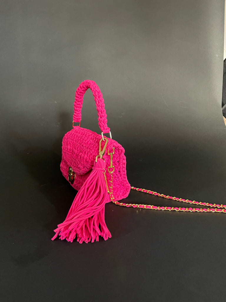 One-of-a-kind magenta pink crochet bag handmade from recycled T-shirts with gold hardware and large tassel by Sarah Aphrodite, wearable as shoulder or handbag