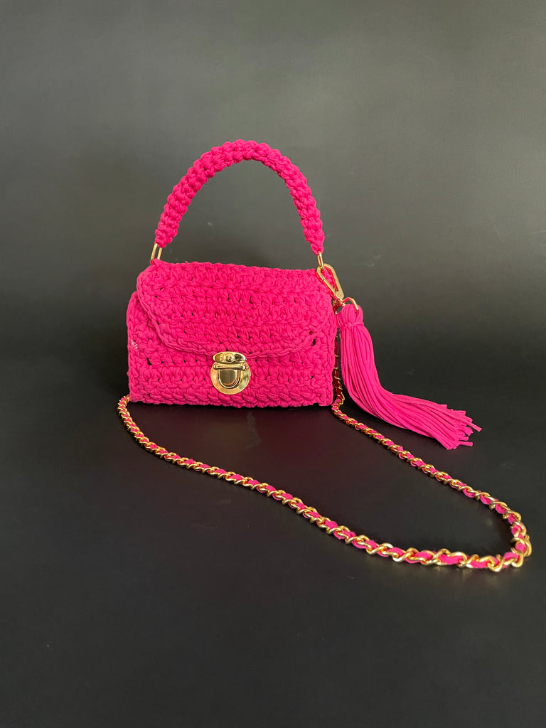 One-of-a-kind magenta pink crochet bag handmade from recycled T-shirts with gold hardware and large tassel by Sarah Aphrodite, wearable as shoulder or handbag