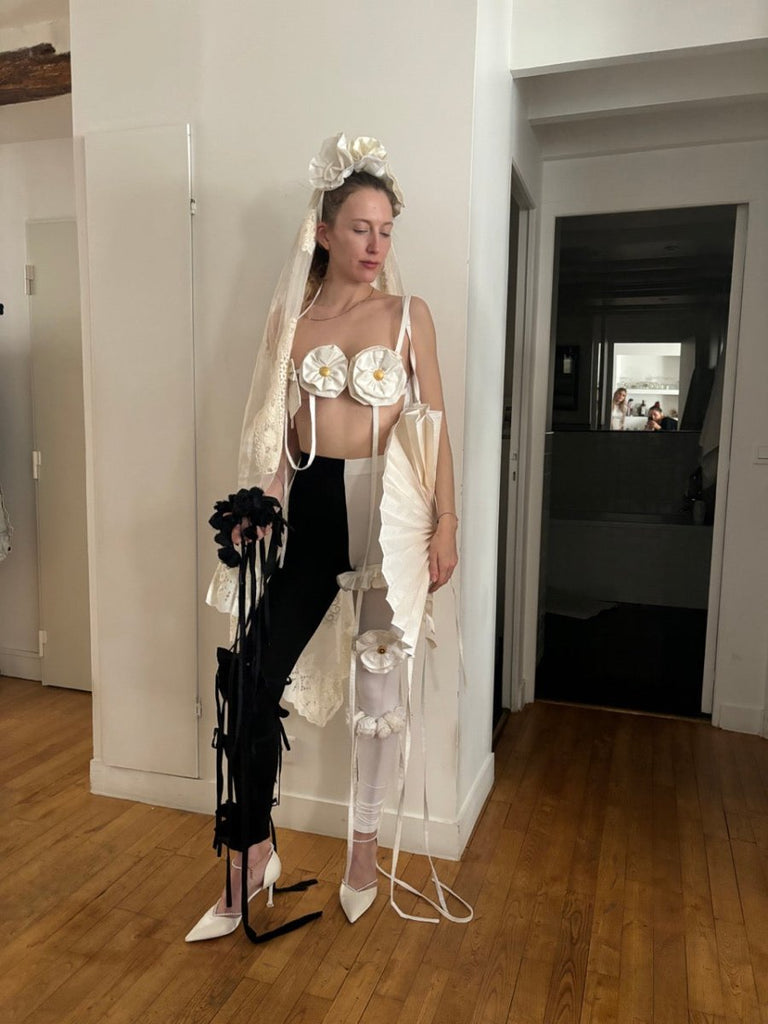 Handmade white flower and bow accessory with gold button centers and long straps by Sarah Aphrodite, made from upcycled fabric scraps, worn as belt or top