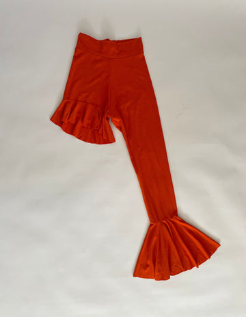 Orange asymmetrical ruffled leggings by Sarah Aphrodite with unique gold hardware, available in Small and Large.

