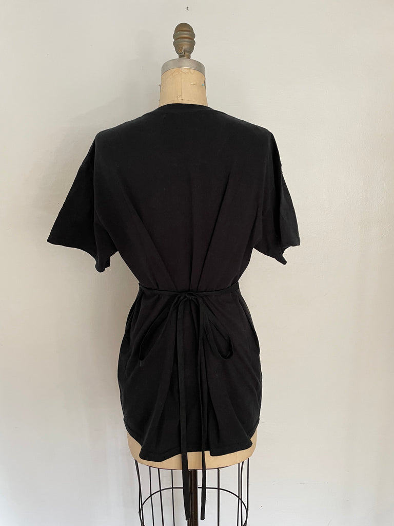 A mannequin displaying a black t-shirt from the back and side ties that accentuate the waist