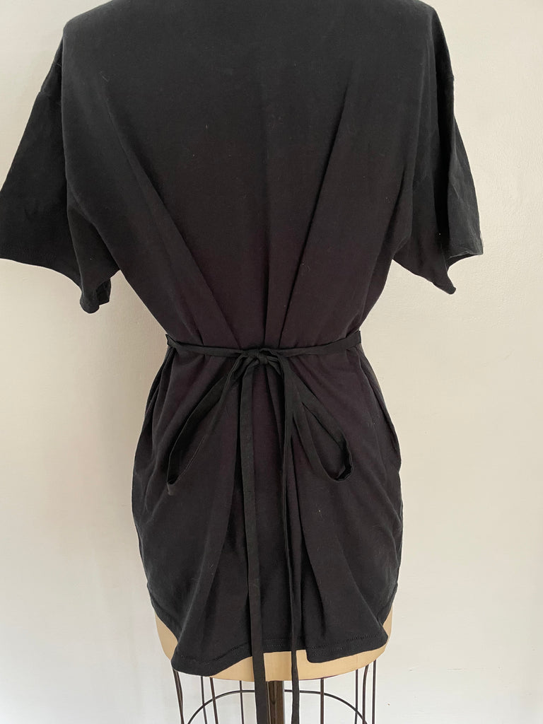 A mannequin displaying a black t-shirt from the back and side ties that accentuate the waist