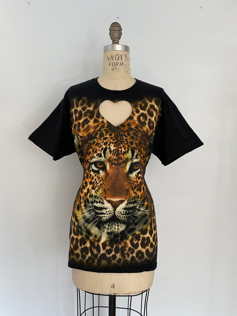 A mannequin displaying a black t-shirt with a heart cut-out featuring a large leopard print graphic.