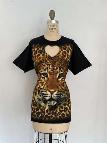 A mannequin displaying a black t-shirt with a heart cut-out featuring a large leopard print graphic.