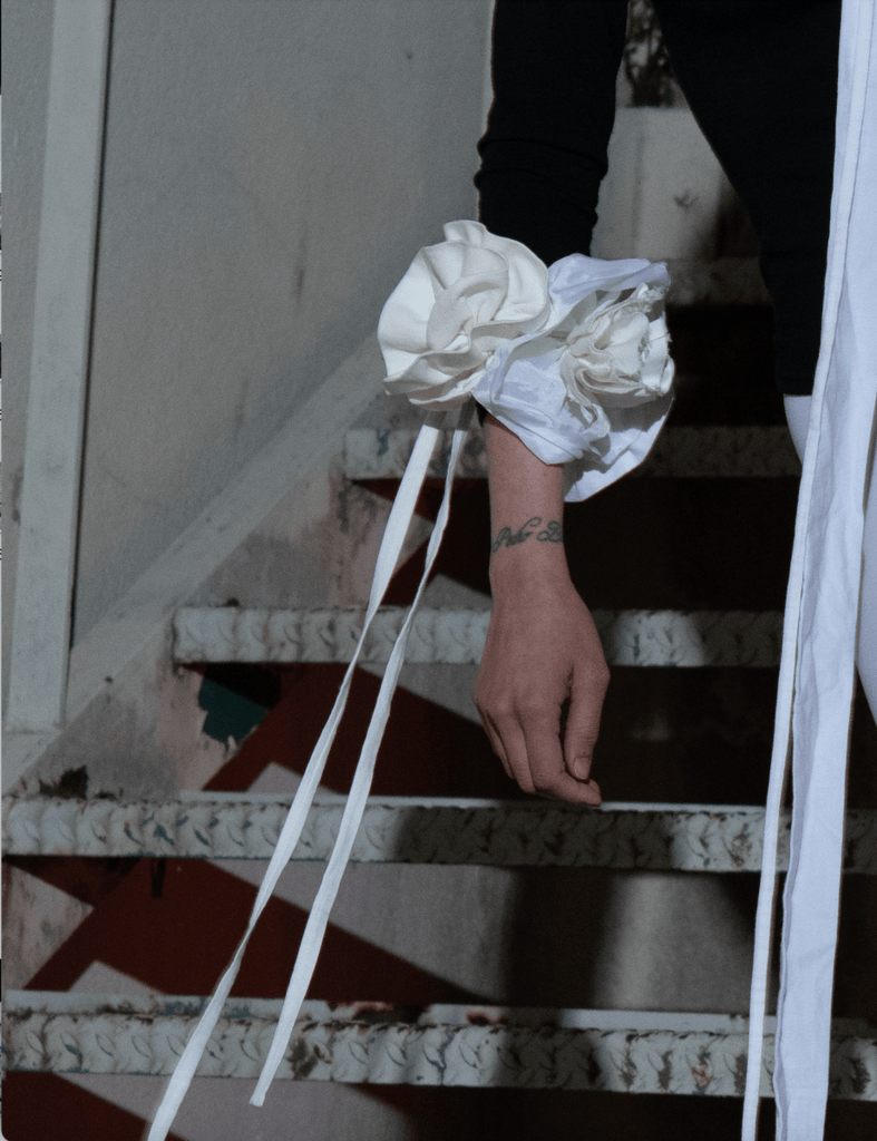 Handmade large flower accessory made from upcycled white cotton and silk fabrics with long white ties by Sarah Aphrodite, wearable as bracelet, belt, or shoulder piece