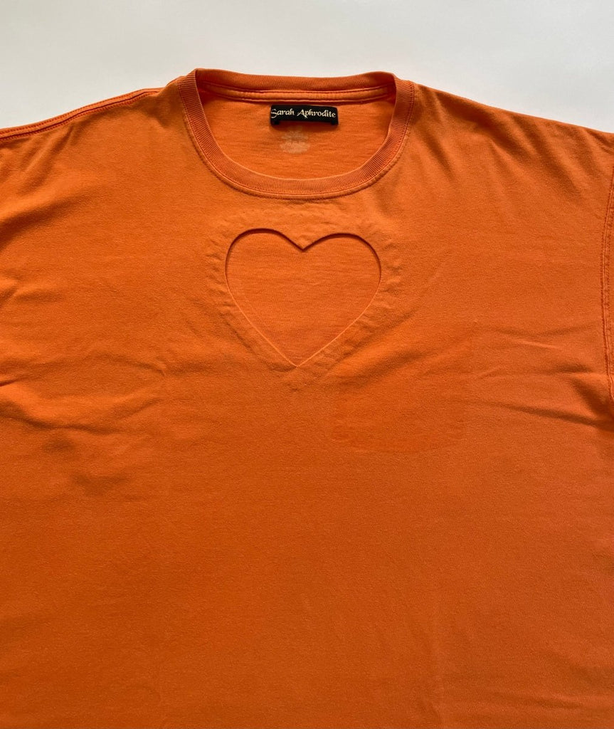 close- up of a heart cut-out in an orange repurposed cotton t-shirt 