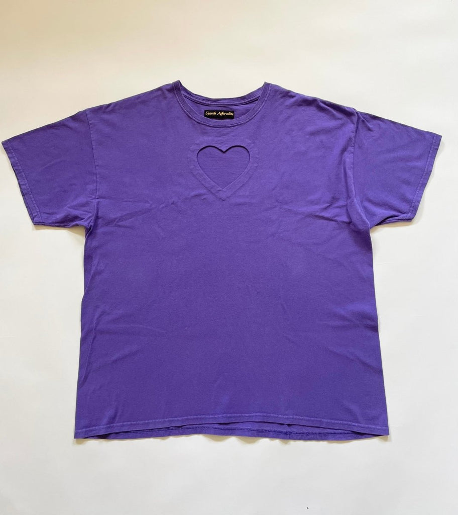 Oversized purple t-shirt with a heart cut-out design on the front, displayed flat on the floor