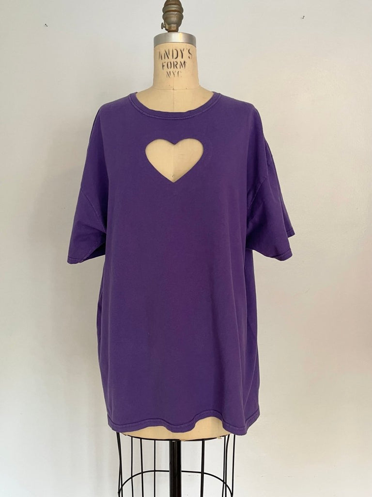 Oversized purple t-shirt with a heart cut-out design on the front, displayed on a mannequin.