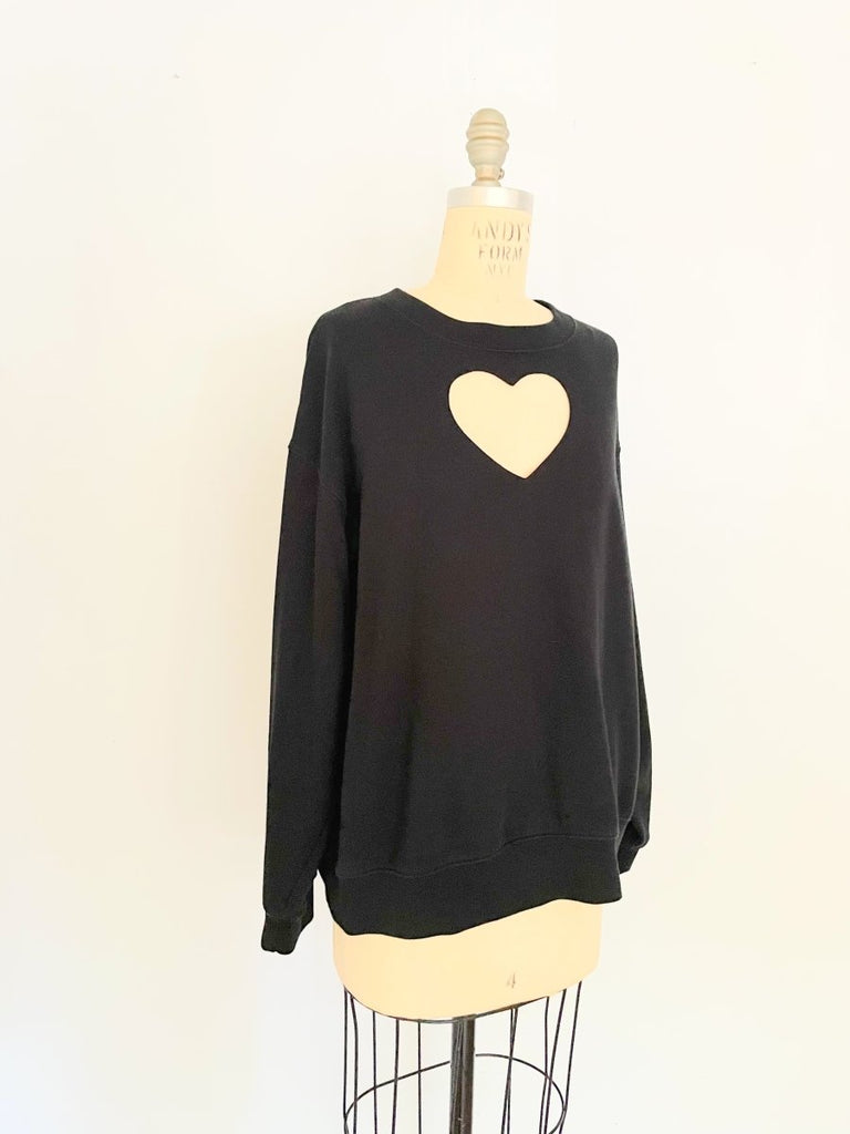 One-of-a-kind sustainable black heart cut-out sweater by Sarah Aphrodite. Handmade from repurposed fabric. Cozy, eco-conscious, and fits Medium.