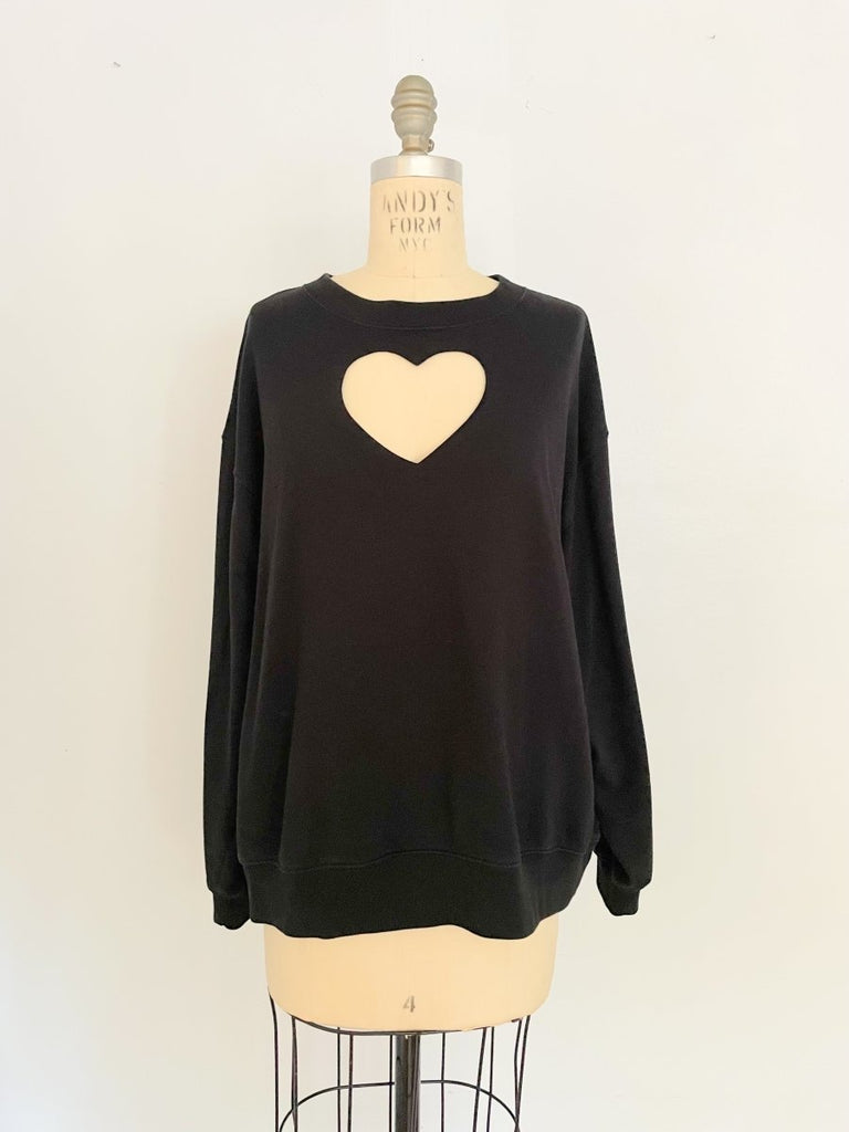One-of-a-kind sustainable black heart cut-out sweater by Sarah Aphrodite. Handmade from repurposed fabric. Cozy, eco-conscious, and fits Medium.