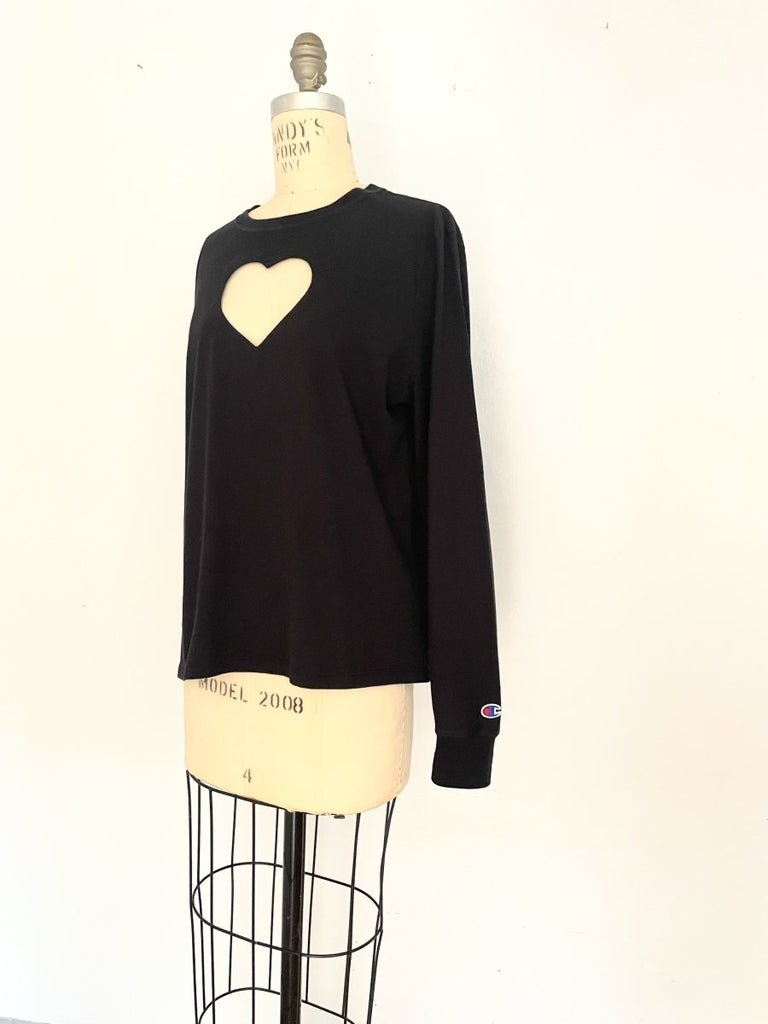 One-of-a-kind sustainable black long sleeve heart cut-out top by Sarah Aphrodite. Handmade from repurposed cotton with Champion logo on sleeve.