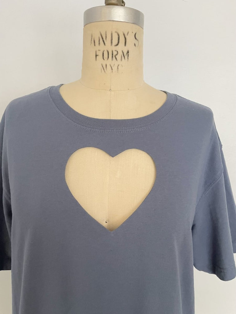 One-of-a-kind sustainable greyish blue t-shirt by Sarah Aphrodite. Large heart cut-out on chest, Eddie Bauer logo on bottom left with paint stain. Fits XS–Large.