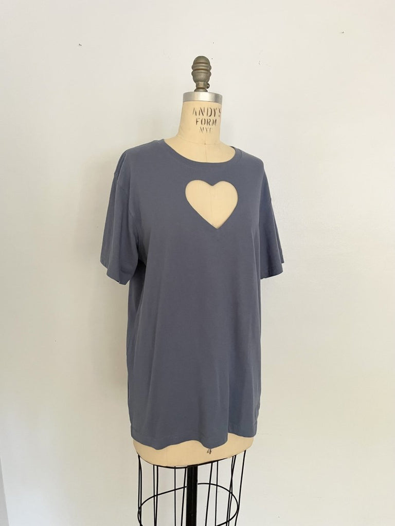 One-of-a-kind sustainable greyish blue t-shirt by Sarah Aphrodite. Large heart cut-out on chest, Eddie Bauer logo on bottom left with paint stain. Fits XS–Large.