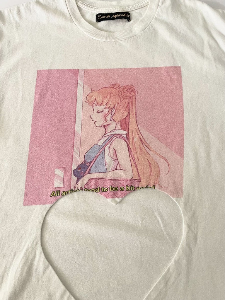 close up of a one-of-a-kind sustainable t-shirt by Sarah Aphrodite, featuring a belly heart cut-out and pink artist “girl” print. Made from repurposed cotton, fits Medium–Large.