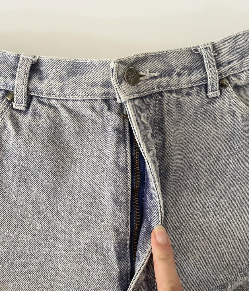 Sustainable one-of-a-kind purple-bluish denim belt by Sarah Aphrodite, handmade from repurposed jeans with triangular cut, zipper closure, back pockets, and frayed edges. Fits 29-inch waist.