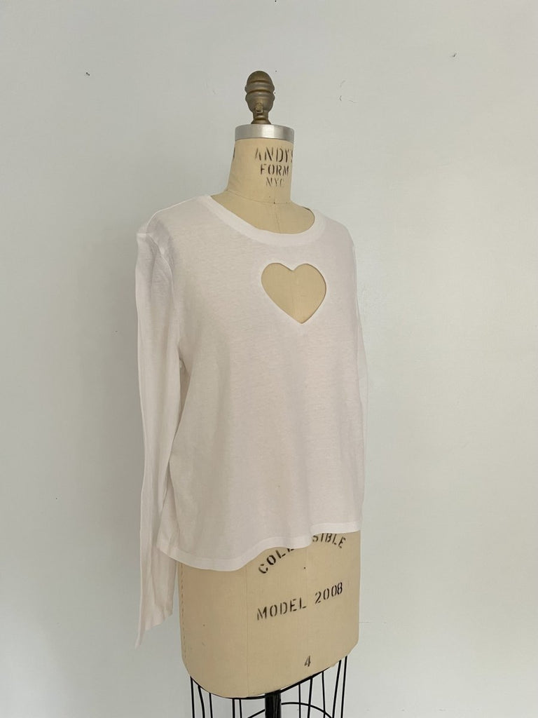 One-of-a-kind sustainable white long sleeve top by Sarah Aphrodite. Features heart cut-out on chest, handmade from repurposed cotton. Fits size Medium.