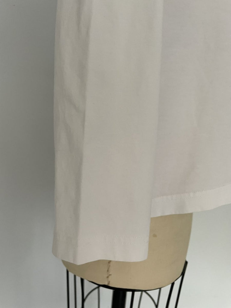 One-of-a-kind sustainable white long sleeve top by Sarah Aphrodite. Heart cut-out on chest, slightly longer length, handmade from repurposed cotton. Fits Medium.