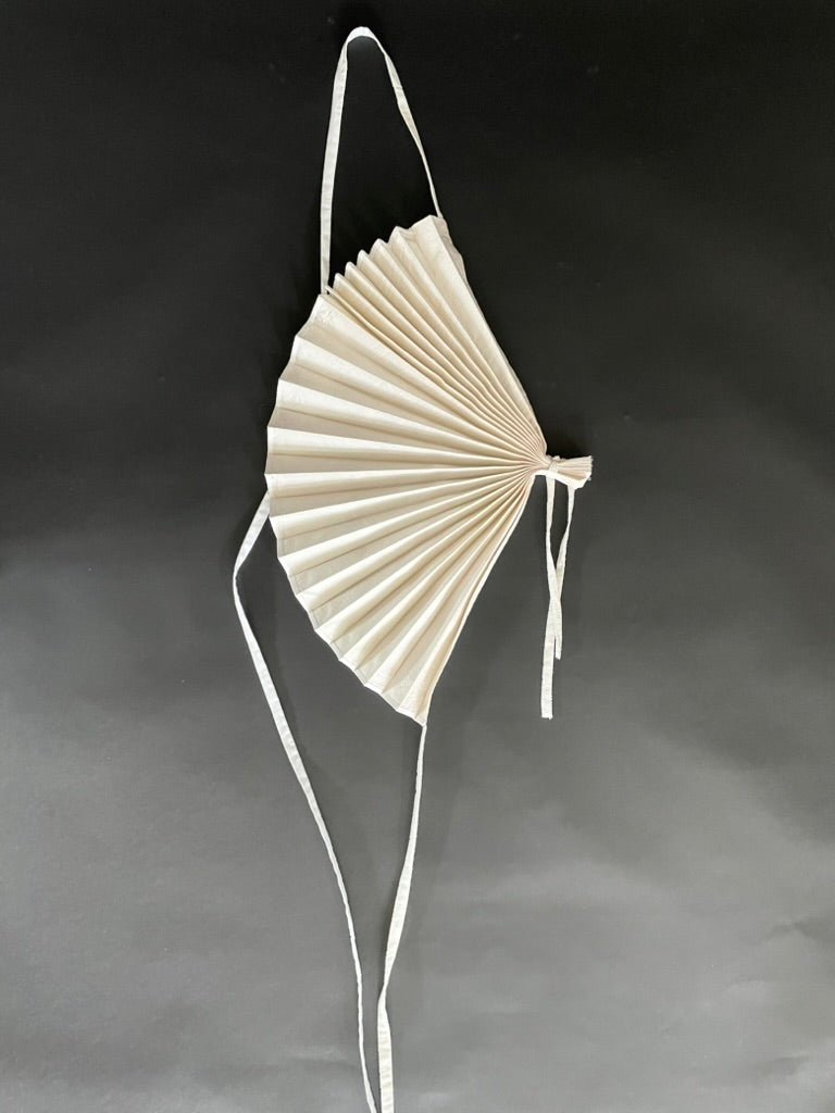 White handmade silk shantung fan accessory with polyester lining by Sarah Aphrodite, worn as an avant-garde shoulder decoration
