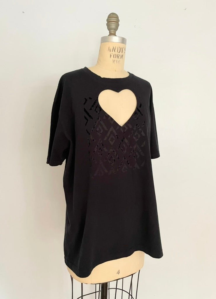 Black tshirt with a heart cut-out on the chest photographed on a mannequin against a white background