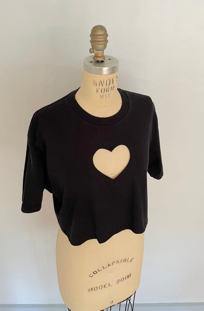 black cropped T-shirt with a hart cut out on the chest displayed on a mannequin against a white background