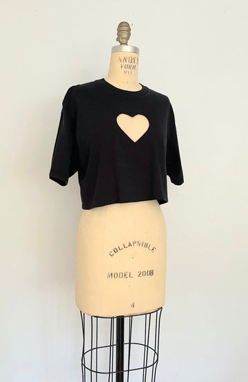 black cropped T-shirt with a hart cut out on the chest displayed on a mannequin against a white background