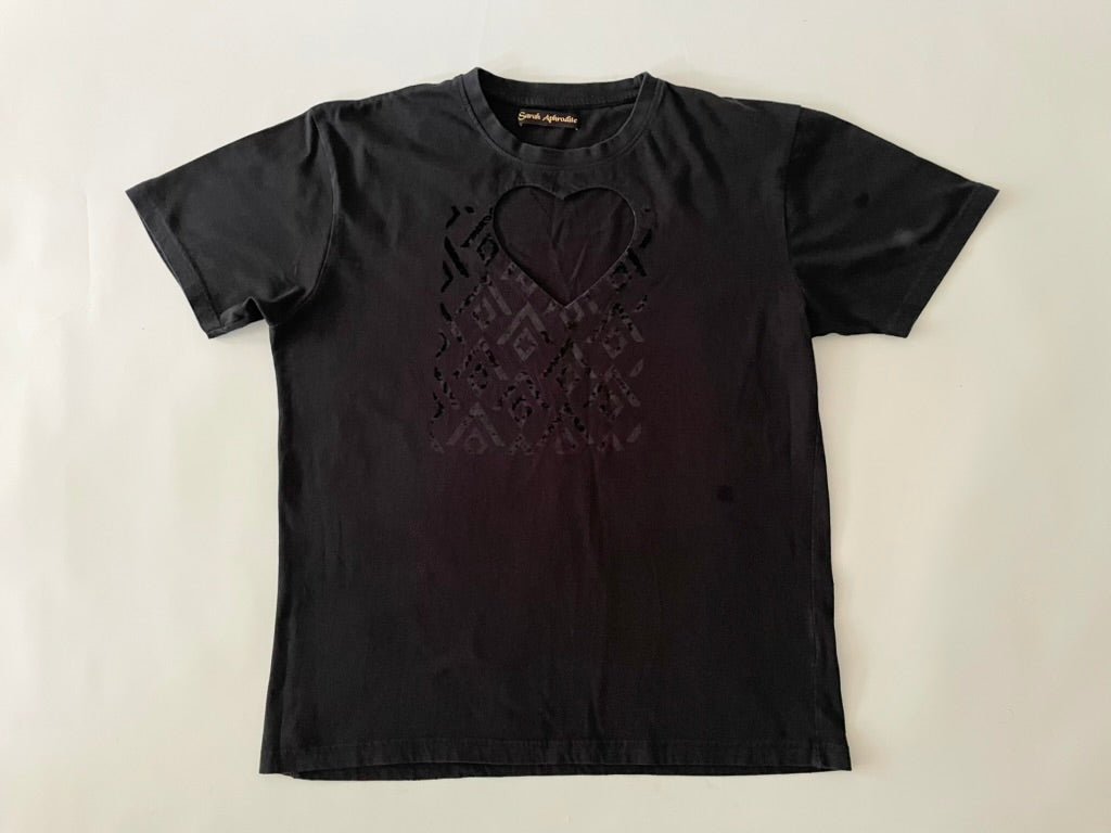 Black tshirt with a heart cut-out on the chest photographed on a mannequin against a white background