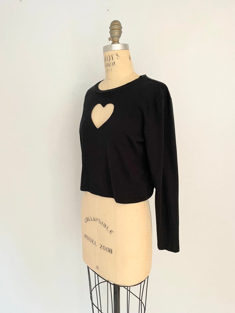 Black long sleeve cotton heart cut out displayed on a mannequin torso from a side angle