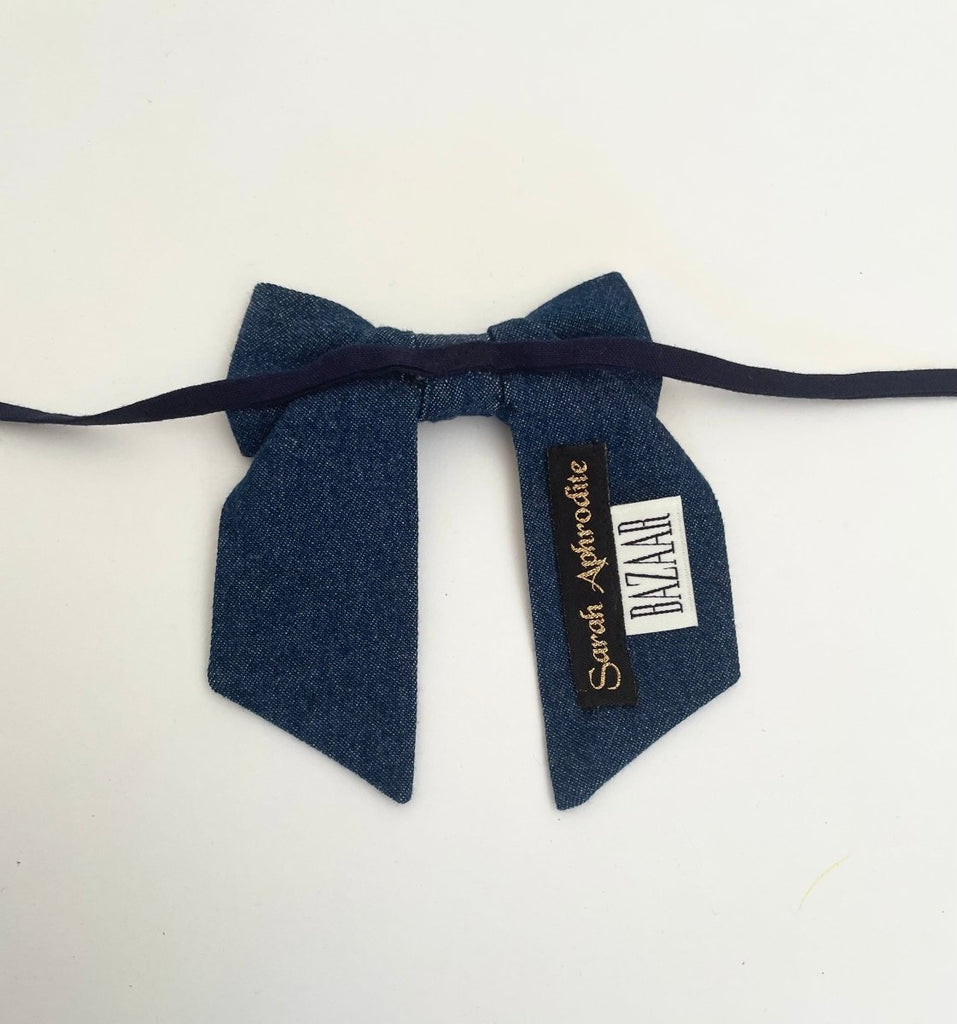 back of a small-sized denim bow accessory with fabric ties displayed against a white background