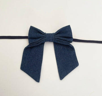 small sized denim bow accessory with fabric ties handmade from upcycled denim, displayed against a white background