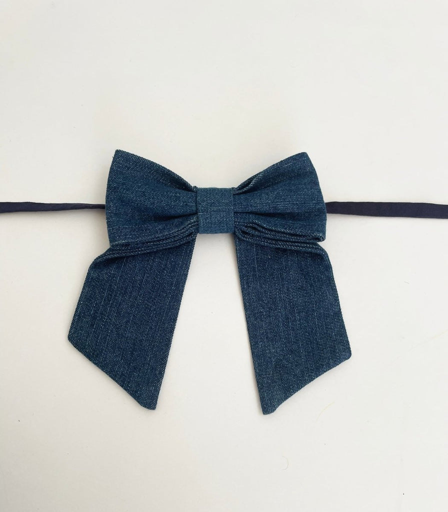Medium-sized denim bow accessory with fabric ties, handmade from upcycled denim, displayed against a white background