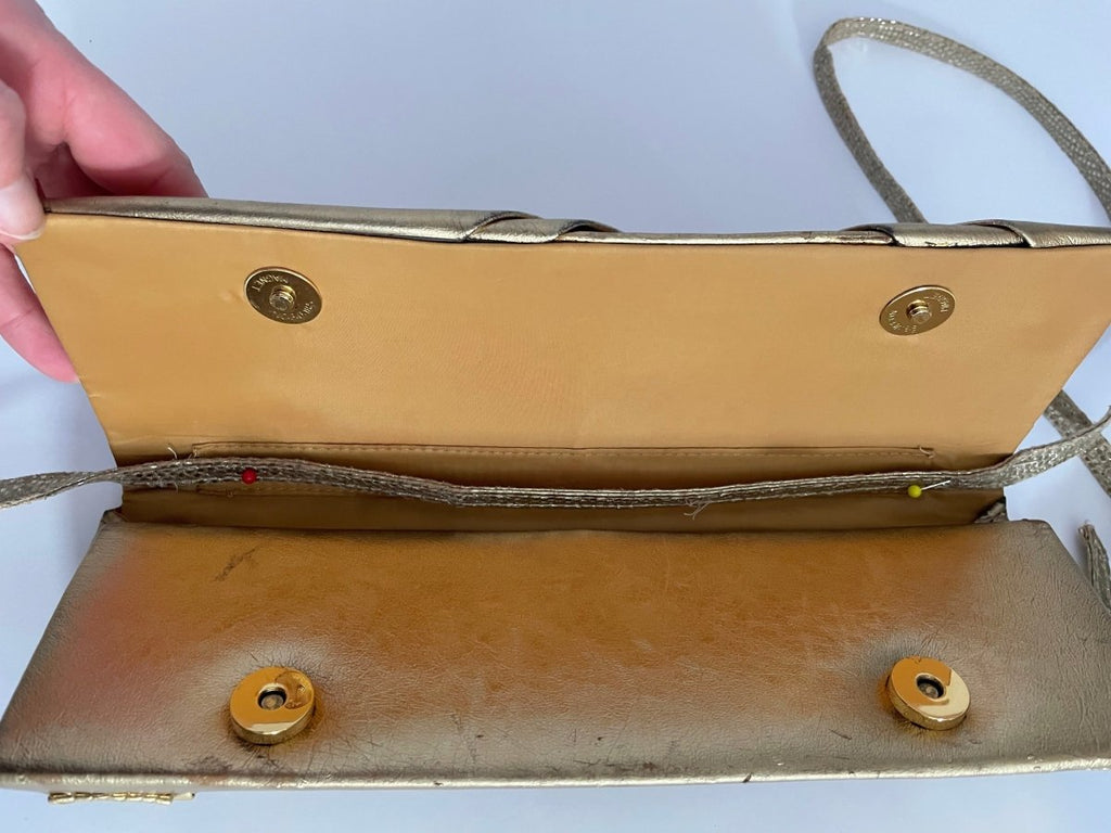 inside  of one-of-a-kind gold pleather archival top bag with a bow on it