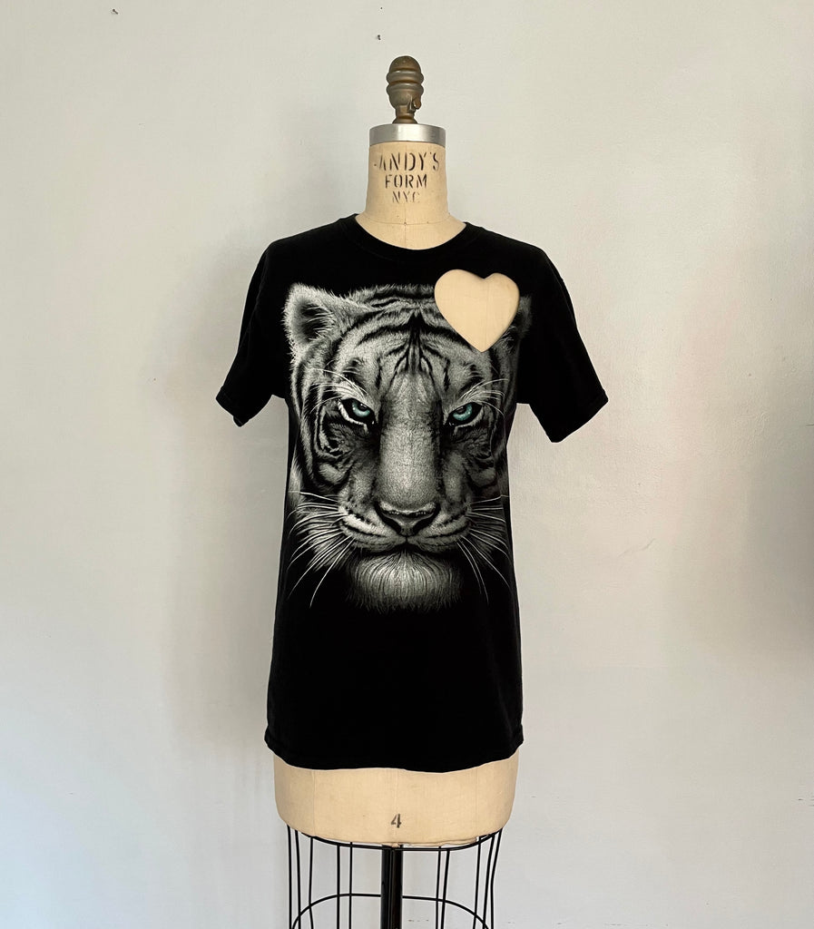 Black t-shirt with a graphic of a white tiger and a heart cut-out on the shoulder- displayed on a mannequin.