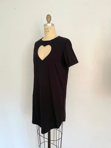 A black t-shirt mini dress with a large heart cut out on the chest displayed on a mannequin.