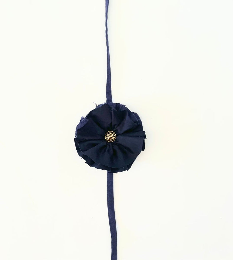 Handmade navy fabric flower accessory with ties and gold nautical button by Sarah Aphrodite. 5.5 inches wide.