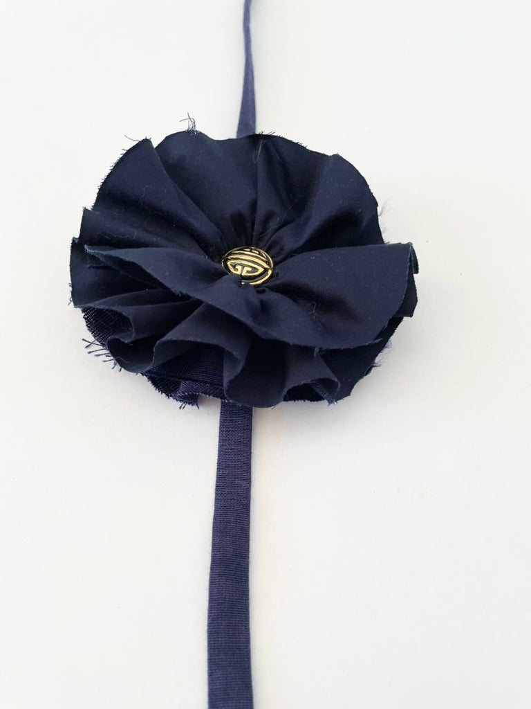Handmade navy fabric flower accessory with ties and with gold nautical button, 5.5 inches wide.