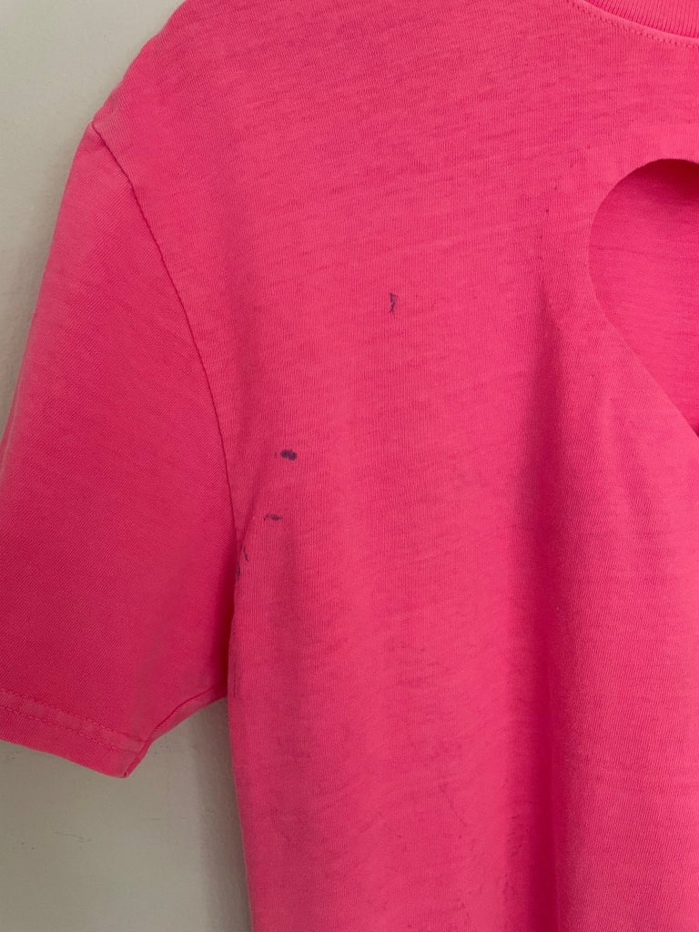 close up of a bright pink t-shirt with a stain near the sleeve