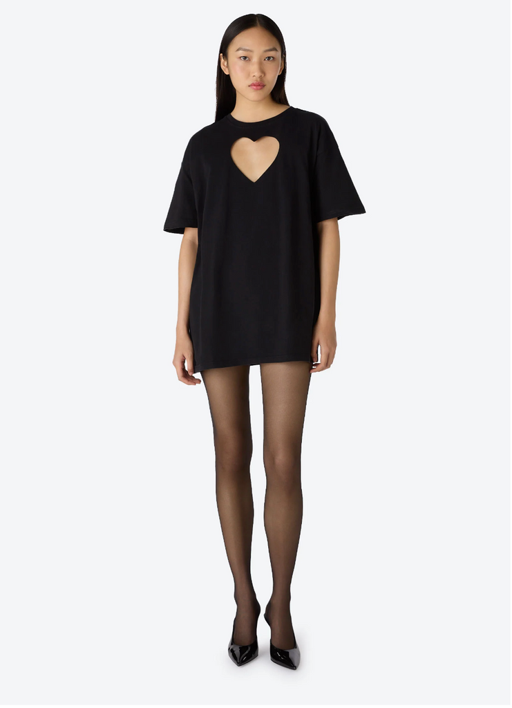 A person wearing an oversized black t-shirt with a large heart-shaped cut-out at the front.