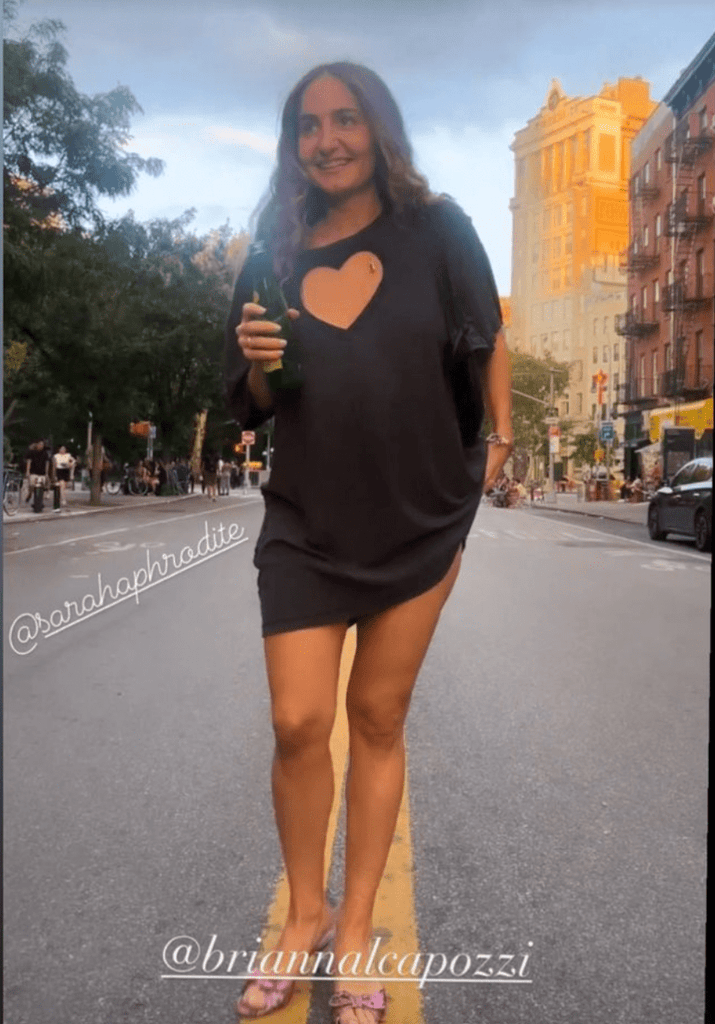 A person Brianna Capozzi wearing an oversized black t-shirt with a large heart-shaped cut-out at the front.