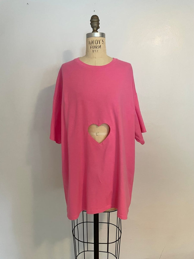 Oversized pink t-shirt with a heart cut-out in the center, displayed on a mannequin.