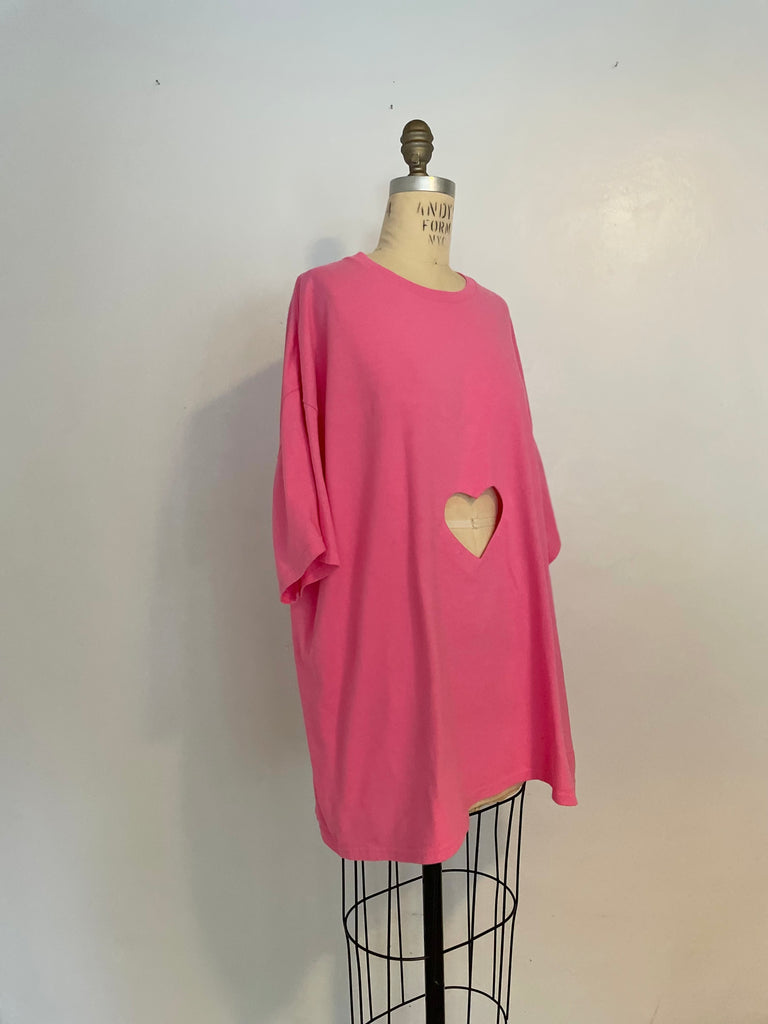 Oversized pink t-shirt with a heart cut-out in the center, displayed on a mannequin.