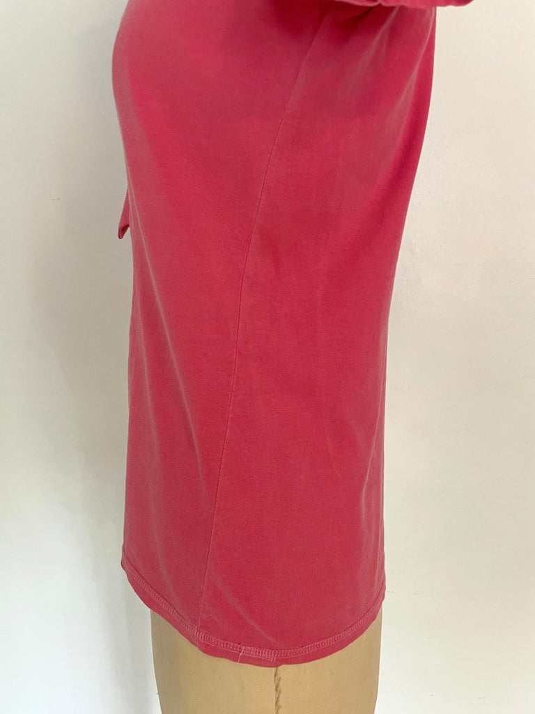 a close up of a twisted side seam on a pink repurposed T-shirt displayed on a mannequin against a white background