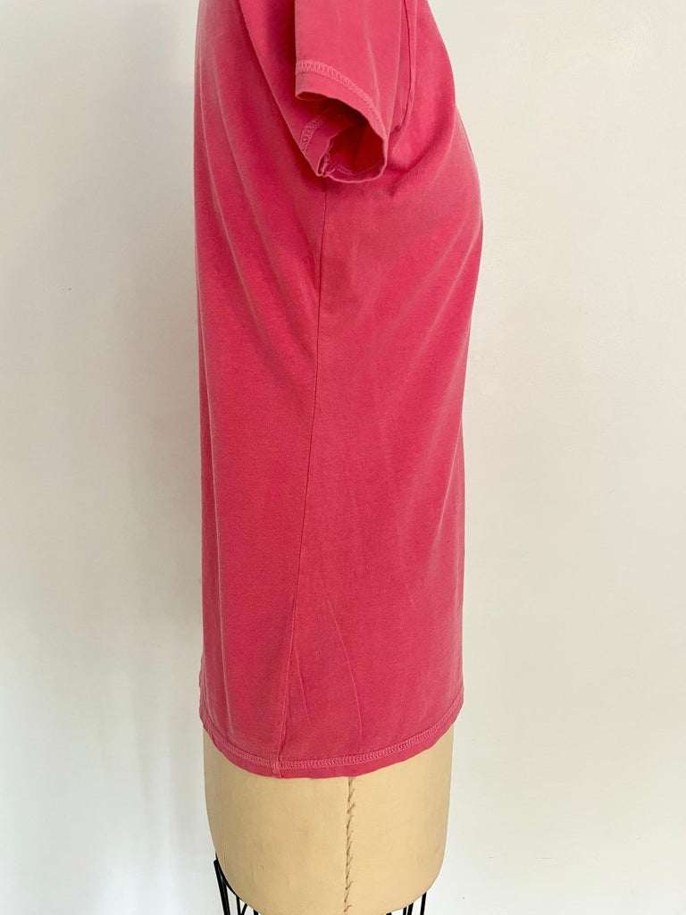 a close up of a twisted side seam on a pink repurposed T-shirt displayed on a mannequin against a white background