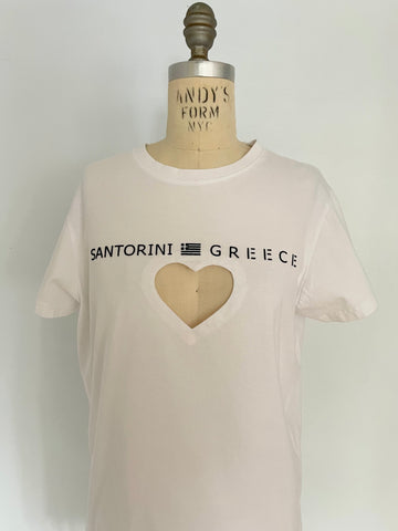 A white t-shirt with 'SANTORINI GREECE' text and a heart cut-out on the front, displayed on a mannequin.