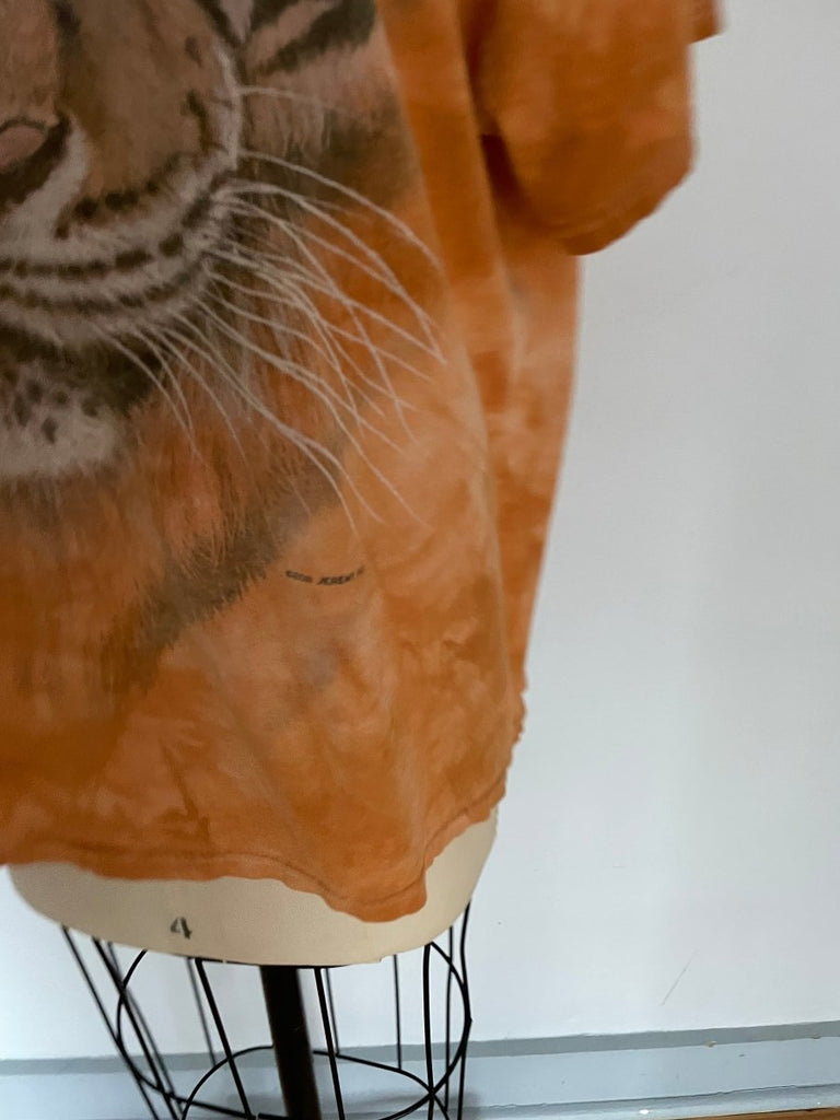 Handmade orange T-shirt with large tiger graphic zoomed in on a small detail  displayed on mannequin.