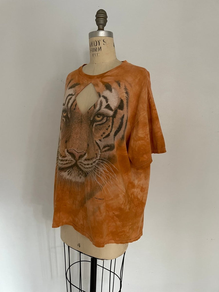 Handmade orange T-shirt with large tiger graphic and diamond-shaped chest cut-out, displayed on mannequin at a 3/4 angle