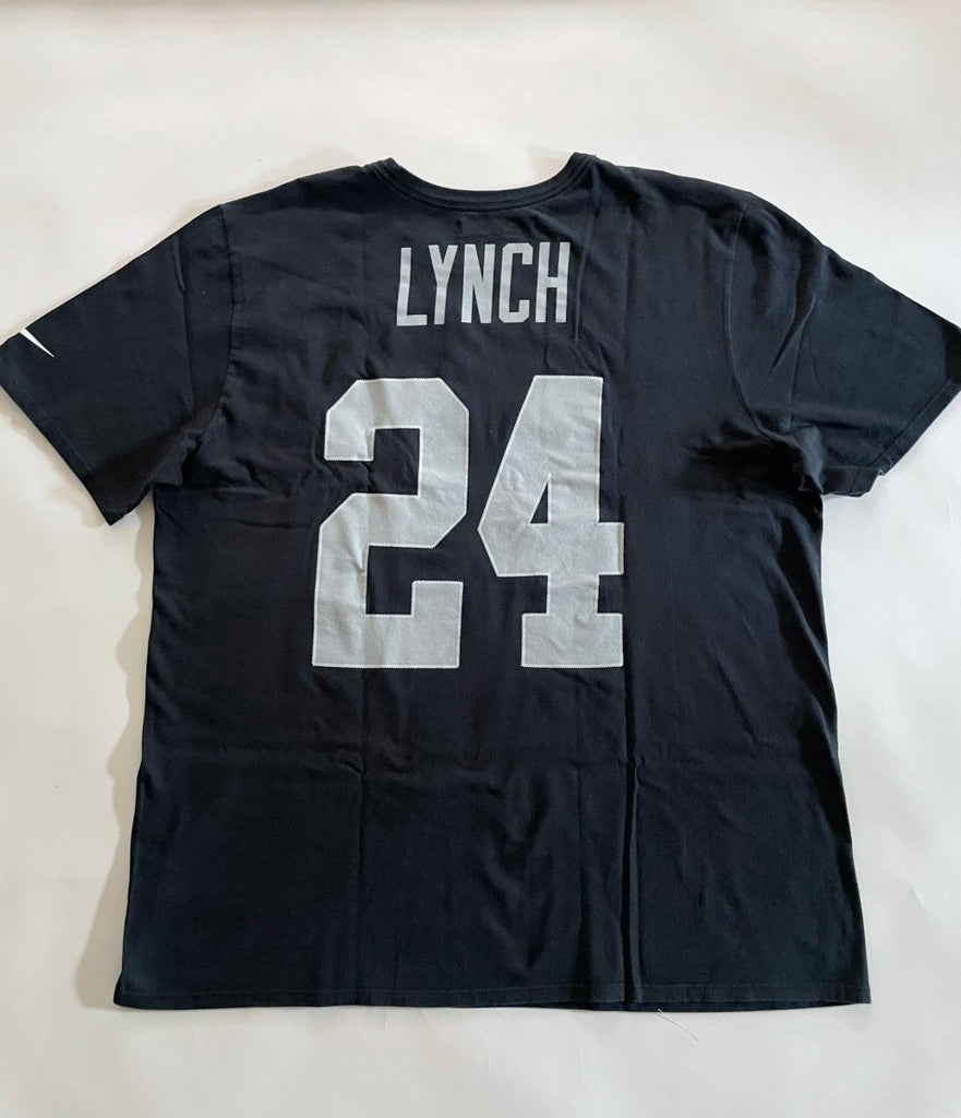 Oversized black t-shirt with a heart cut-out design and the number 24 printed on the front and the back, displayed flat on the floor