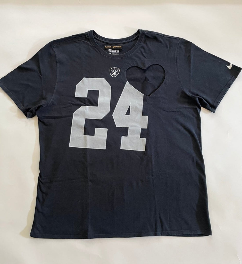 Oversized black t-shirt with a heart cut-out design and the number 24 printed on the front, displayed on a mannequin.