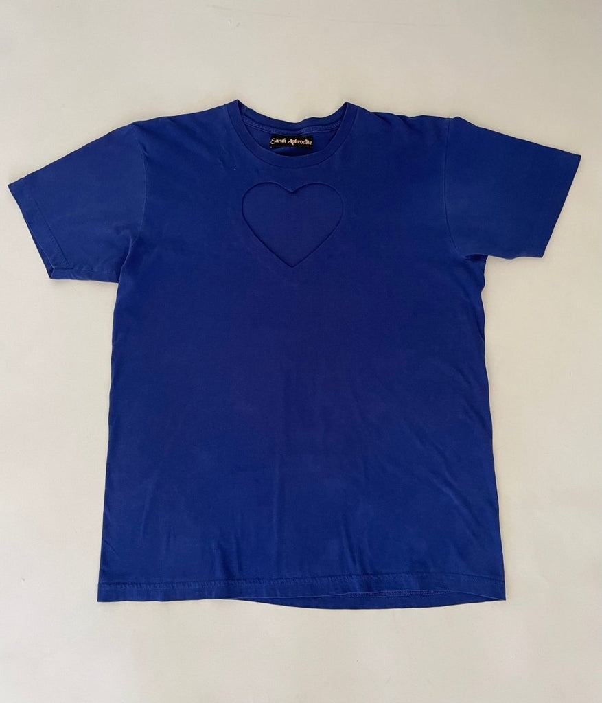 Ultramarine blue t-shirt with a heart cut-out design in the center, displayed flat on the floor