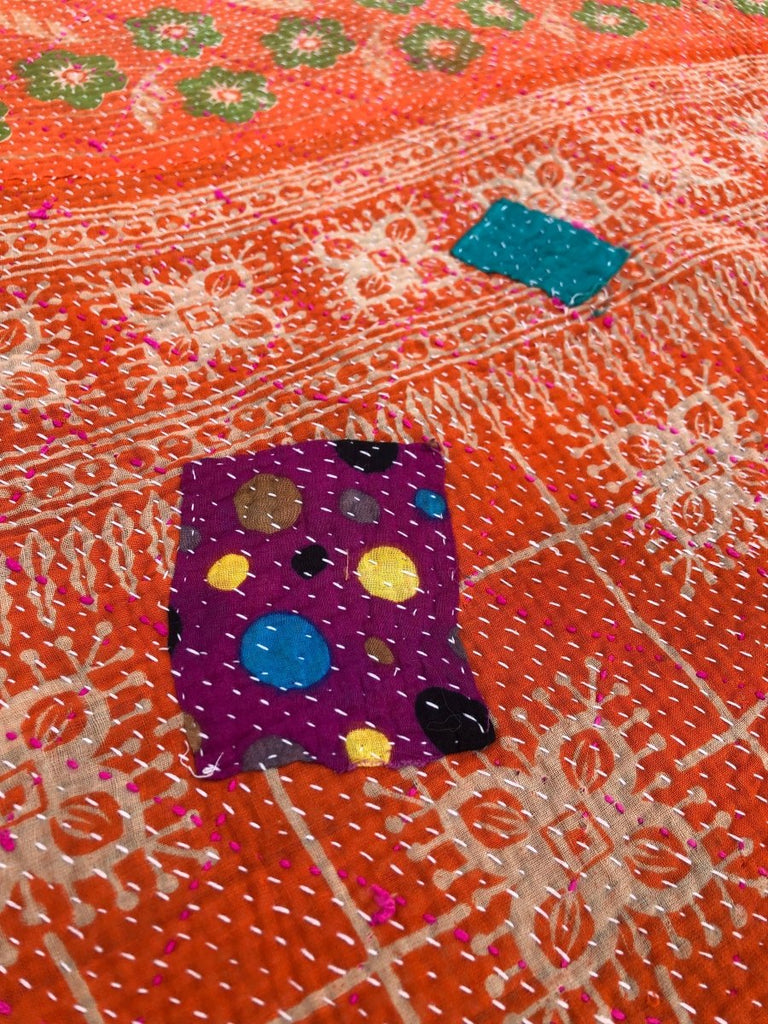 Decorative patch with colorful polka dots on an orange fabric background